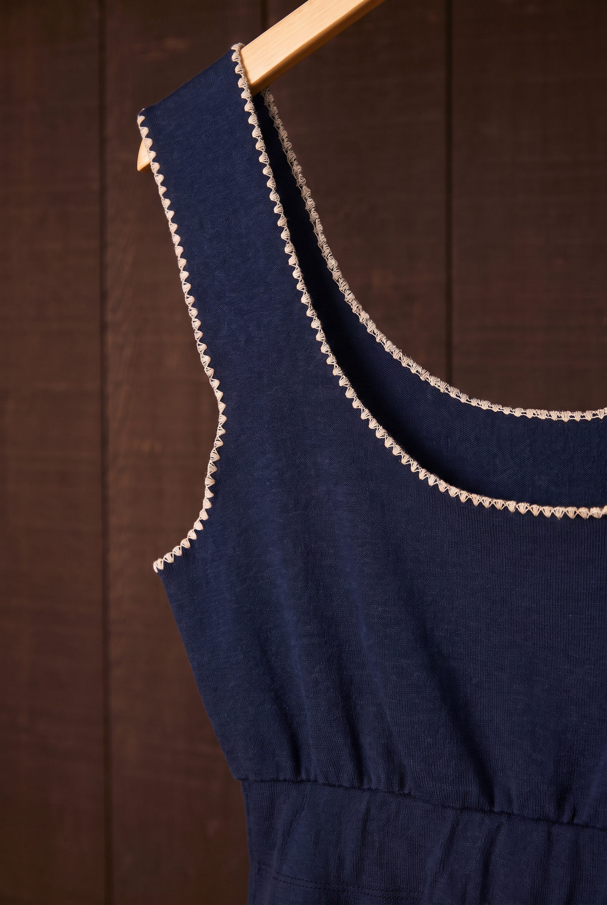 Close-up of indigo crop tank with cream shell-stitch neckline