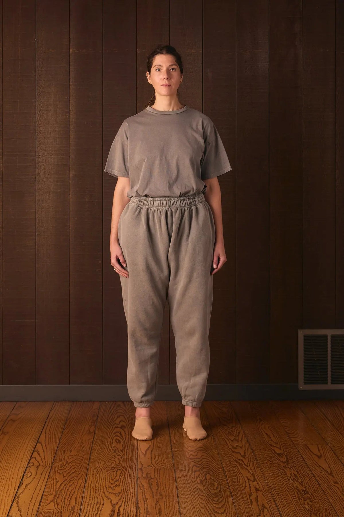 Den Shirt worn against a wooden paneled wall (shown in OurCarbon gray for fit)