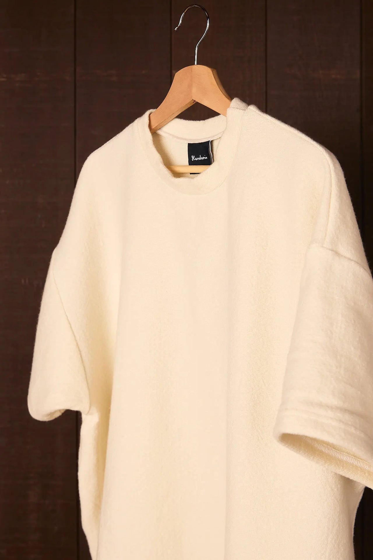 Climate Beneficial garment on a hanger against a dark background