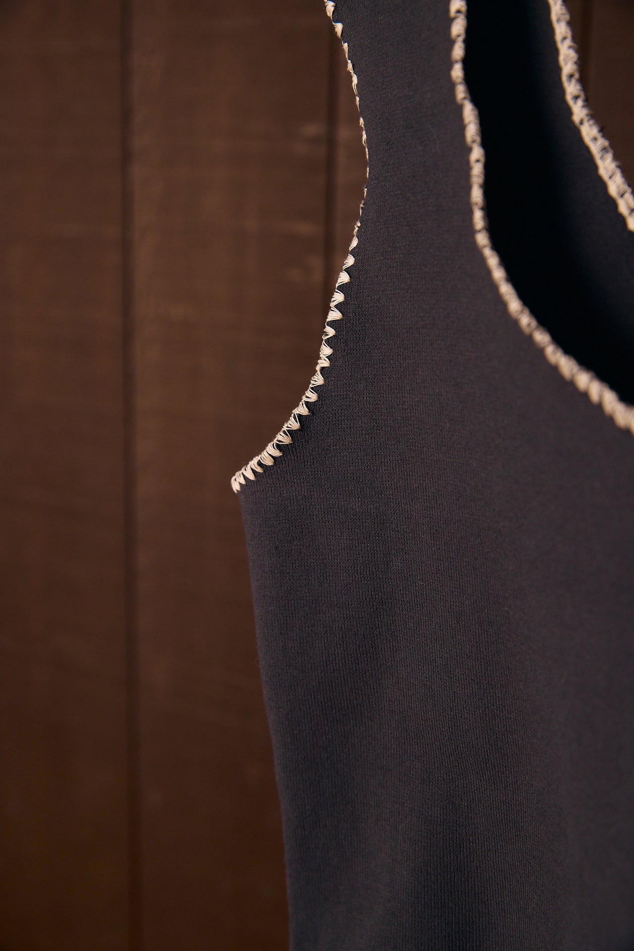 Close-up of a dark fabric garment with a shell stitch 