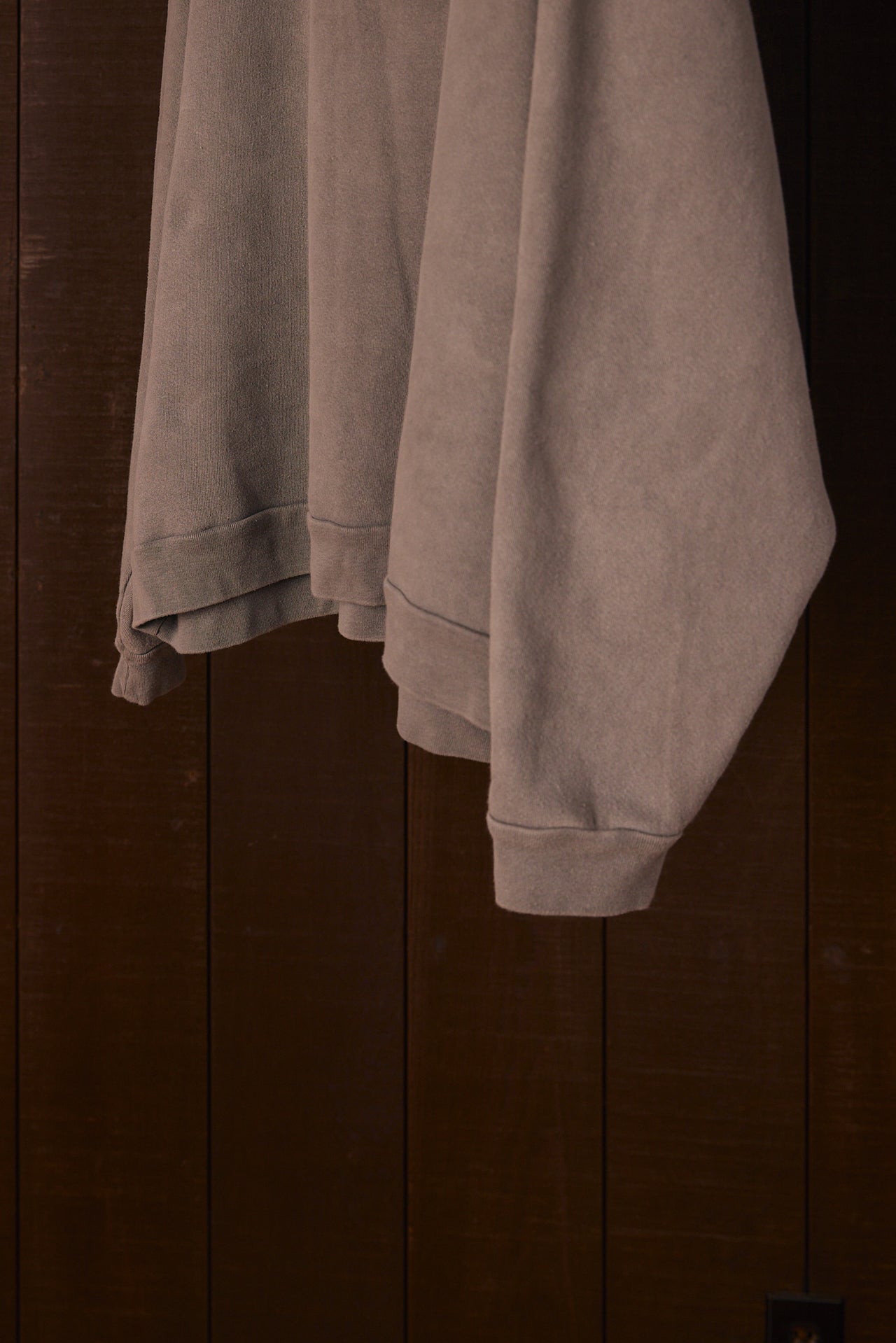 Gray sweatshirt draped over a wooden surface