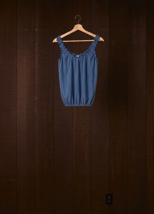 Indigo plant-dyed cotton jersey Cloud Camisoul on a wooden hanger against a dark wood wall